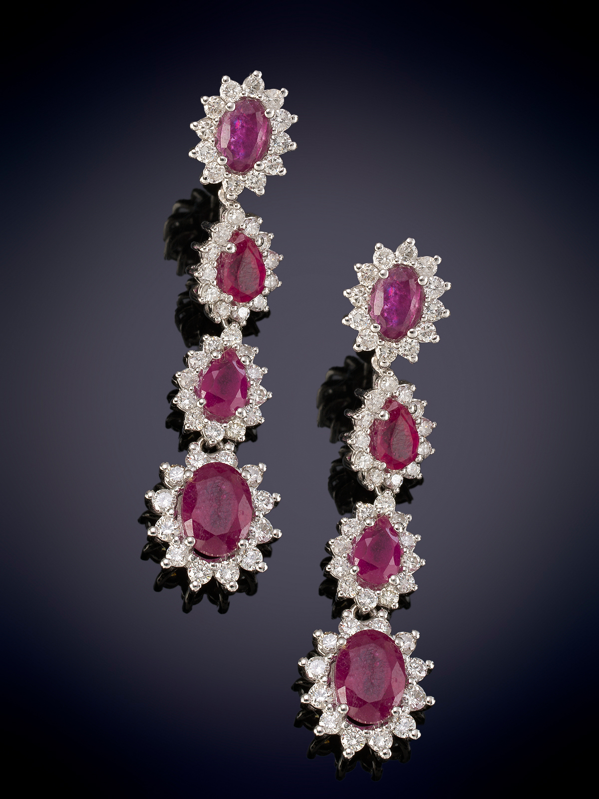 PENDIENTES LARGOS CON MOVIMIENTO FORMADOS POR CUATRO ROSETONES DE RUBIES ORLADOS DE BRILLANTES....