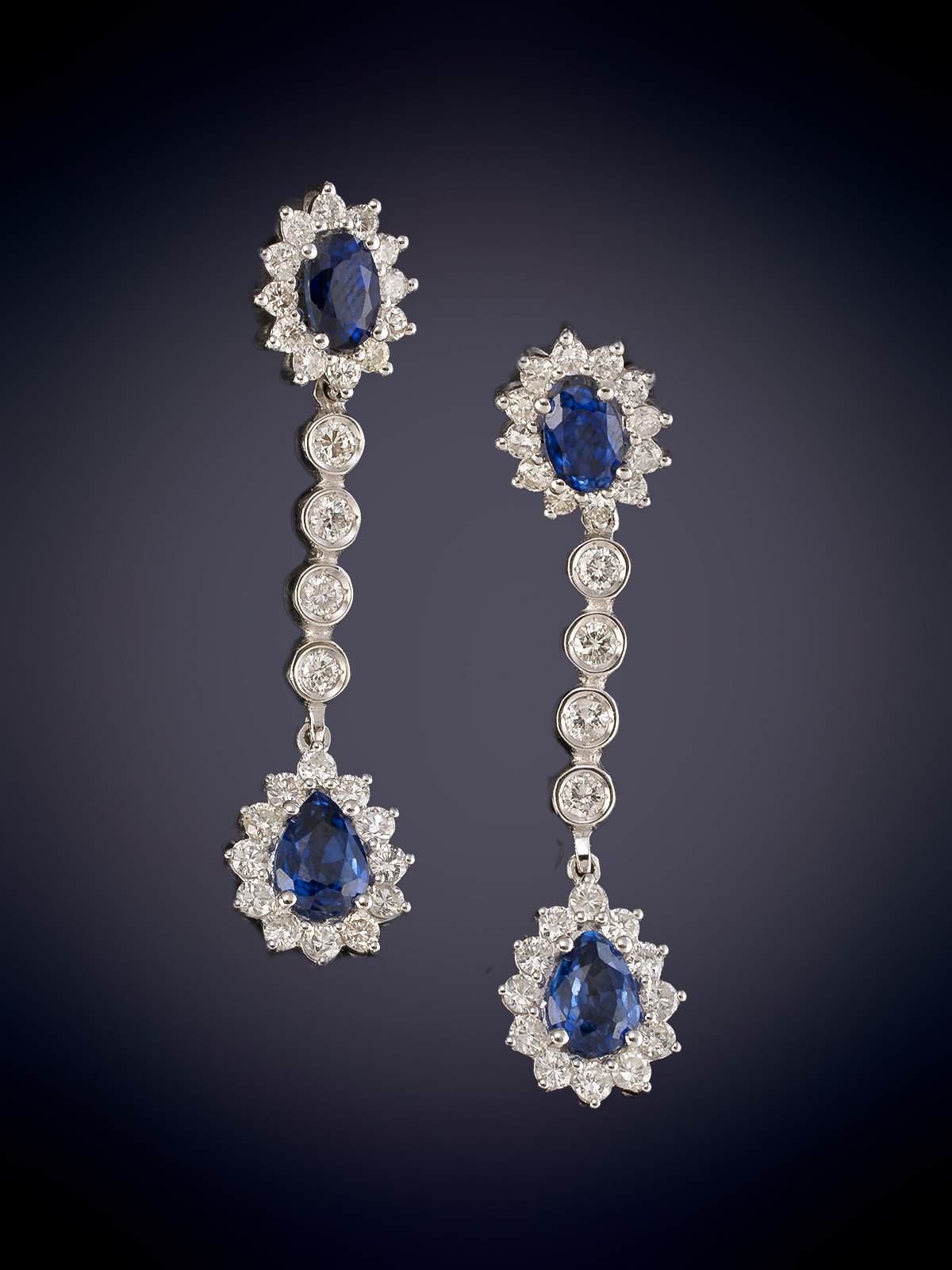 PENDIENTES LARGOS CON MOVIMIENTO CON DOBLE ORLA DE ZAFIROS Y BRILLANTES.  Montura en oro blanco de...