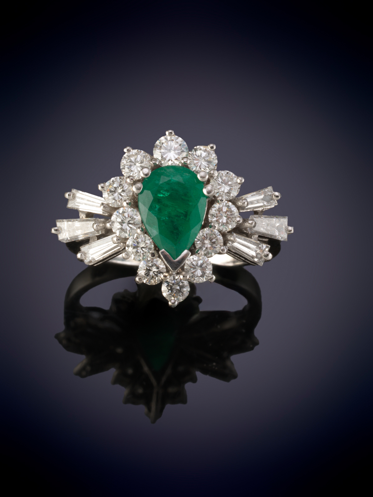 SORTIJA CON ESMERALDA PERILLA ORLADA DE BRILLANTES Y FLANQUEADA POR TRAPECIOS DE DIAMANTE. Montura...