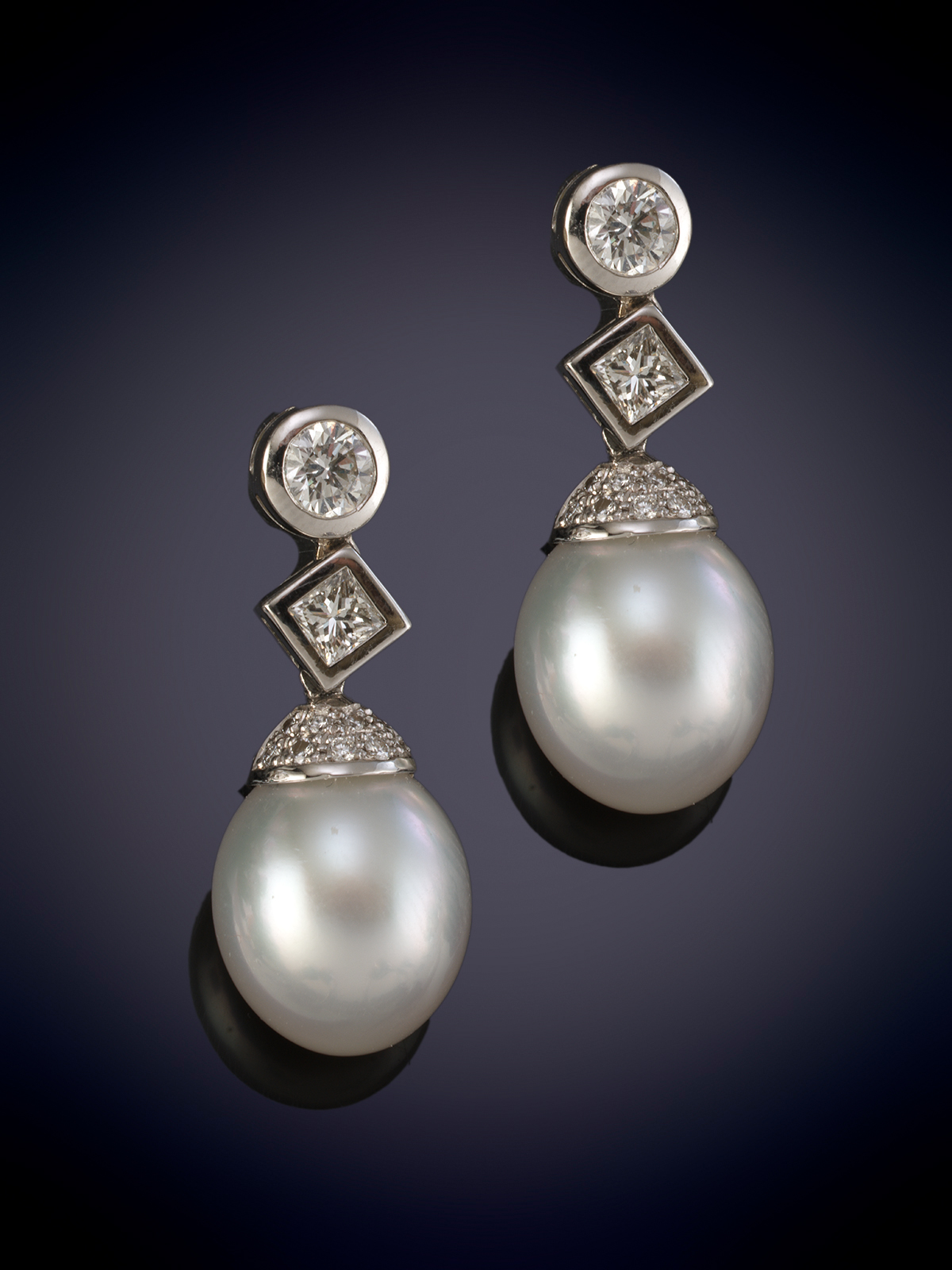 ELEGANTES PENDIENTES  DE PERLAS AUSTRALIANAS DE INTENSO ORIENTE  QUE PENDEN DE UN CHATÓN DE BRILLANTES Y PRINCESAS. 