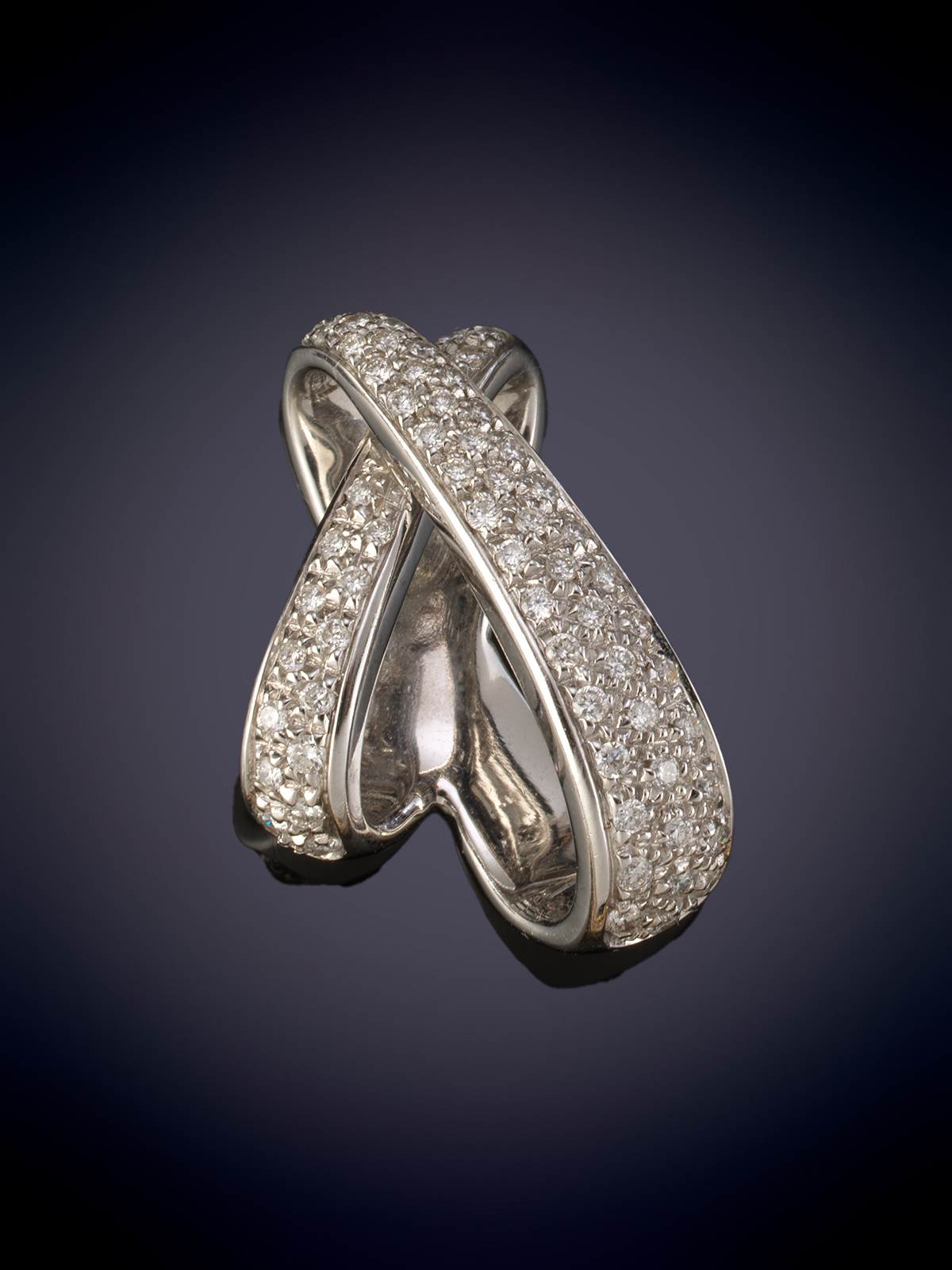 COLGANTE EN FORMA DE ASPA CON PAVÉ DE DIAMANTES.  Montura en oro blanco de 18k.