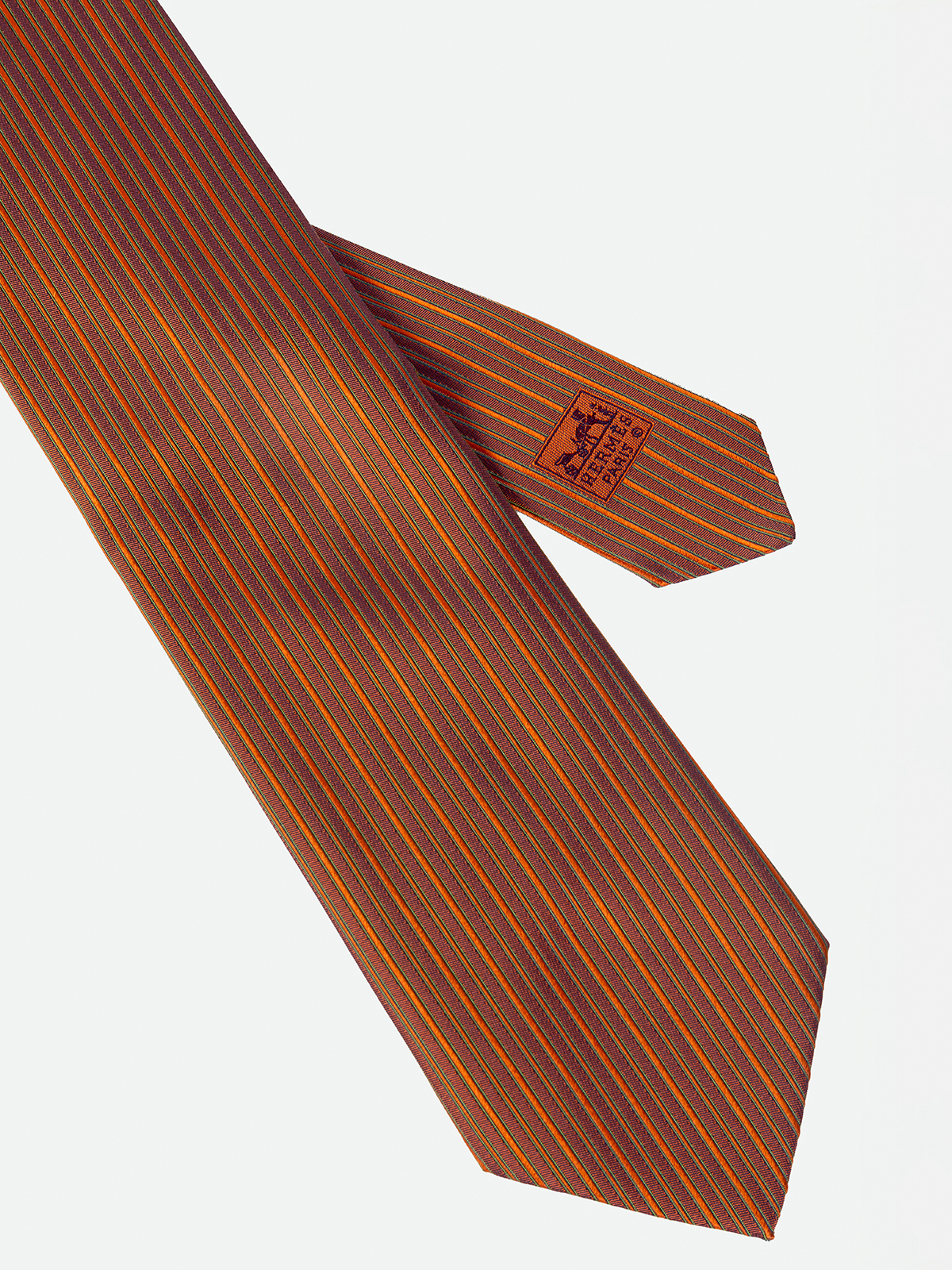 HERMÉS. CORBATA DE LINEAS VERTICALES QUE COMBINATONOS COLOR TEJA.
