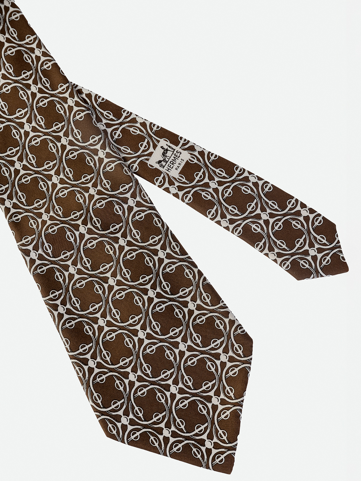 HERMÉS. CORBATA DE FONDO MARRON CHOCOLATE CON DIBUJO DE CELOSIAS EN COLOR BEIGE.