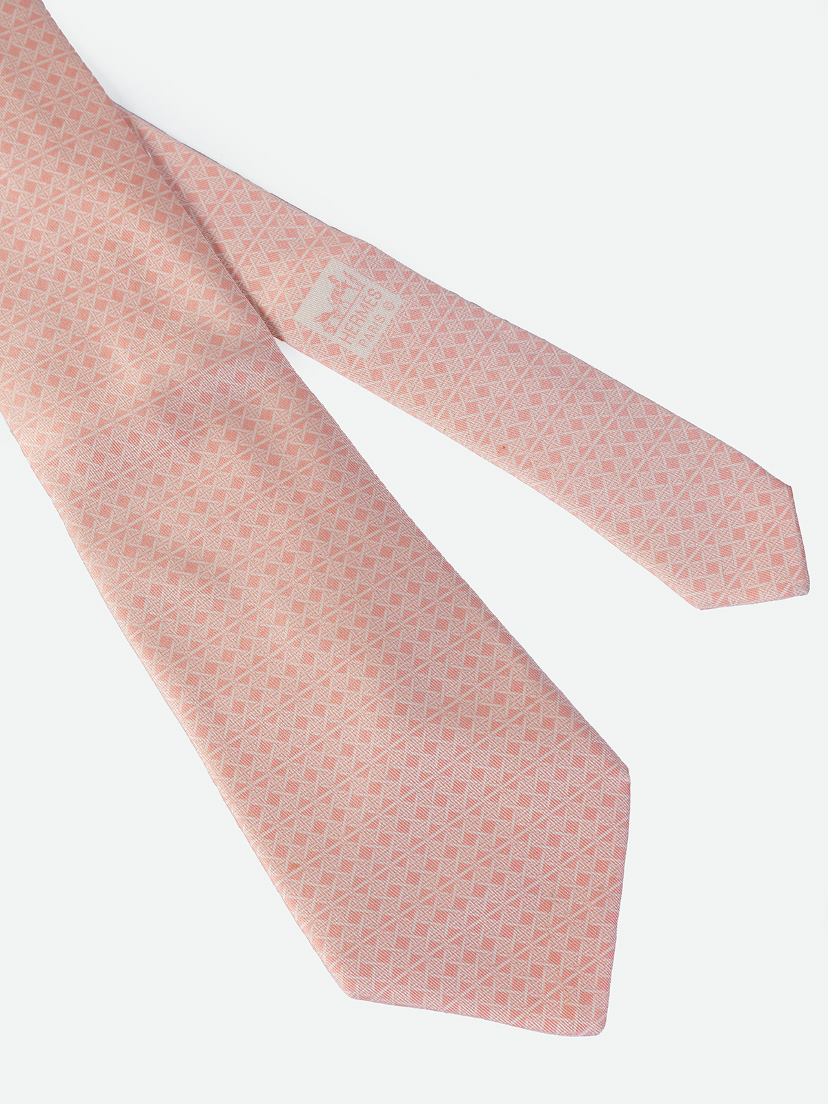 HERMÉS. CORBATA EN TONOS ROSADOS CON DETALLE DE MOTIVOS GEOMETRICOS EN FORMA DE ROMBOS.