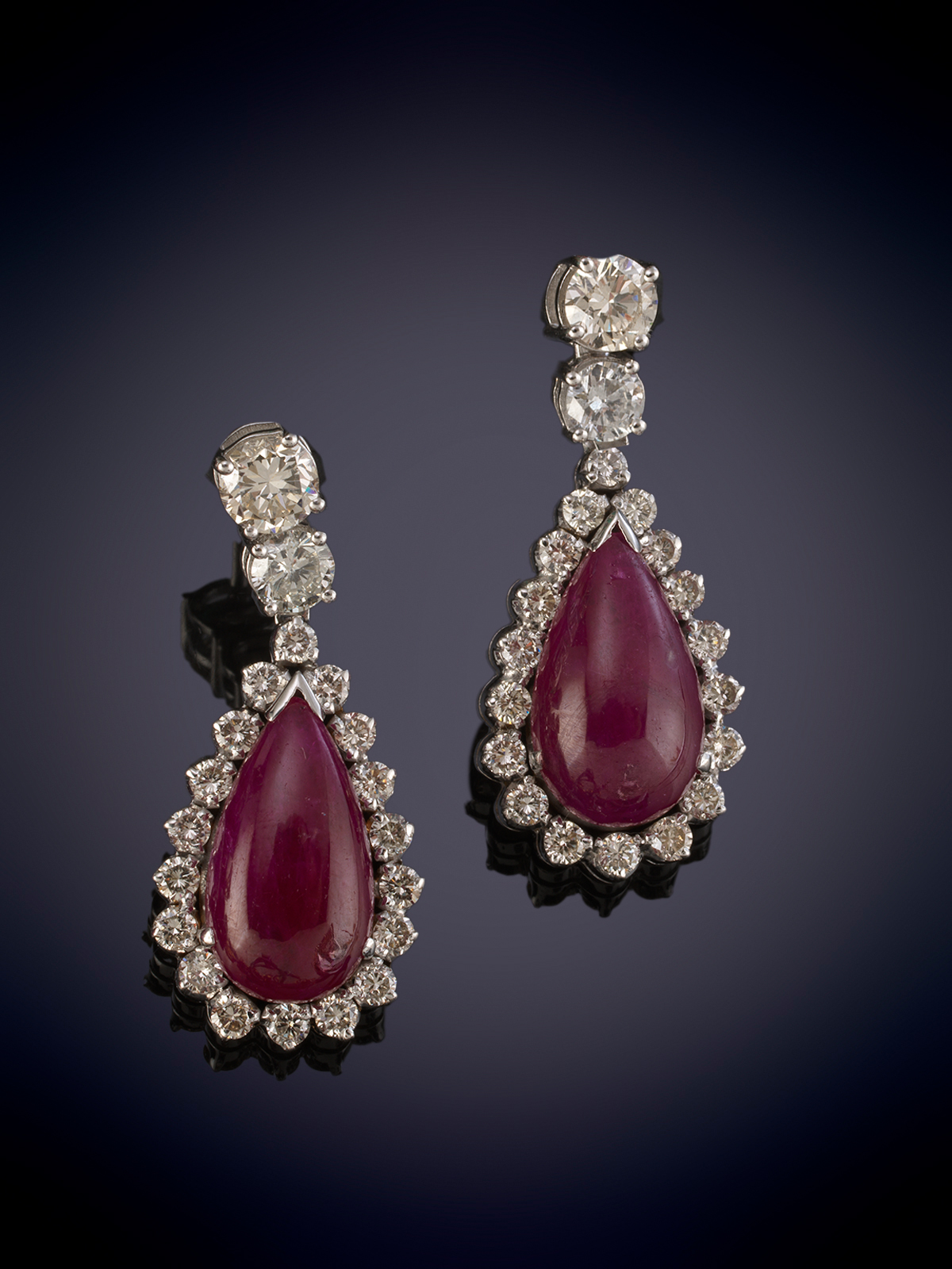 ELEGANTES PENDIENTES CON MOVIMIENTO DE RUBIES TALLA CABUJÓN ORLADOS DE BRILLANTES. Montura en oro...