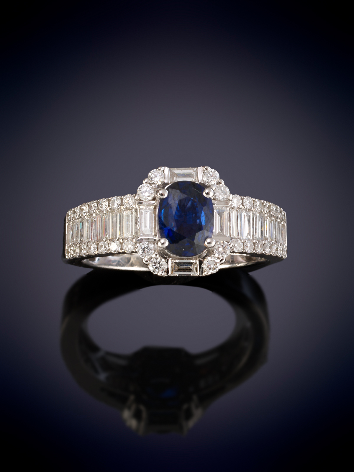 SORTIJA CLASICA DE ZAFIRO OVAL ADORNADO CON HILERAS DE BAGUETTES DE DIAMANTES. Montura en oro...