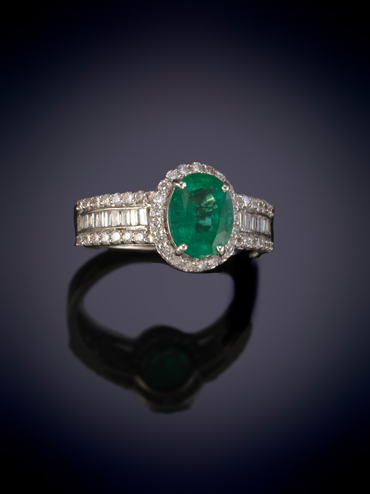 SORTIJA ROSETON CON UNA ESMERALDA OVAL ORLADA DE BRILLANTES. MONTURA DECORADA CON BAGUETTES Y...