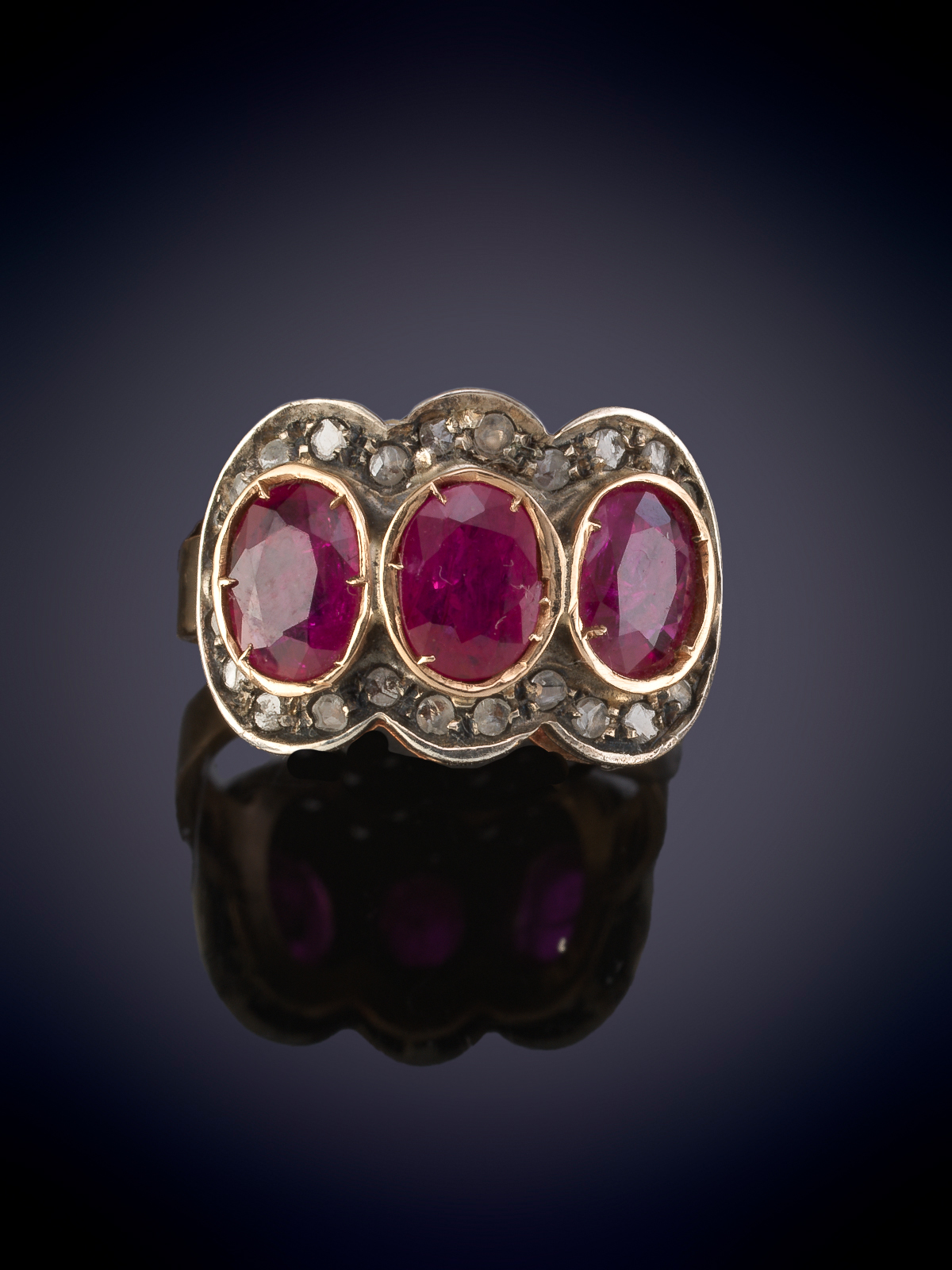 SORTIJA TRESILLO CON TRES RUBIES ORLADOS DE PEQUEÑOS BRILLANTES. Montura en oro rosa de 9k