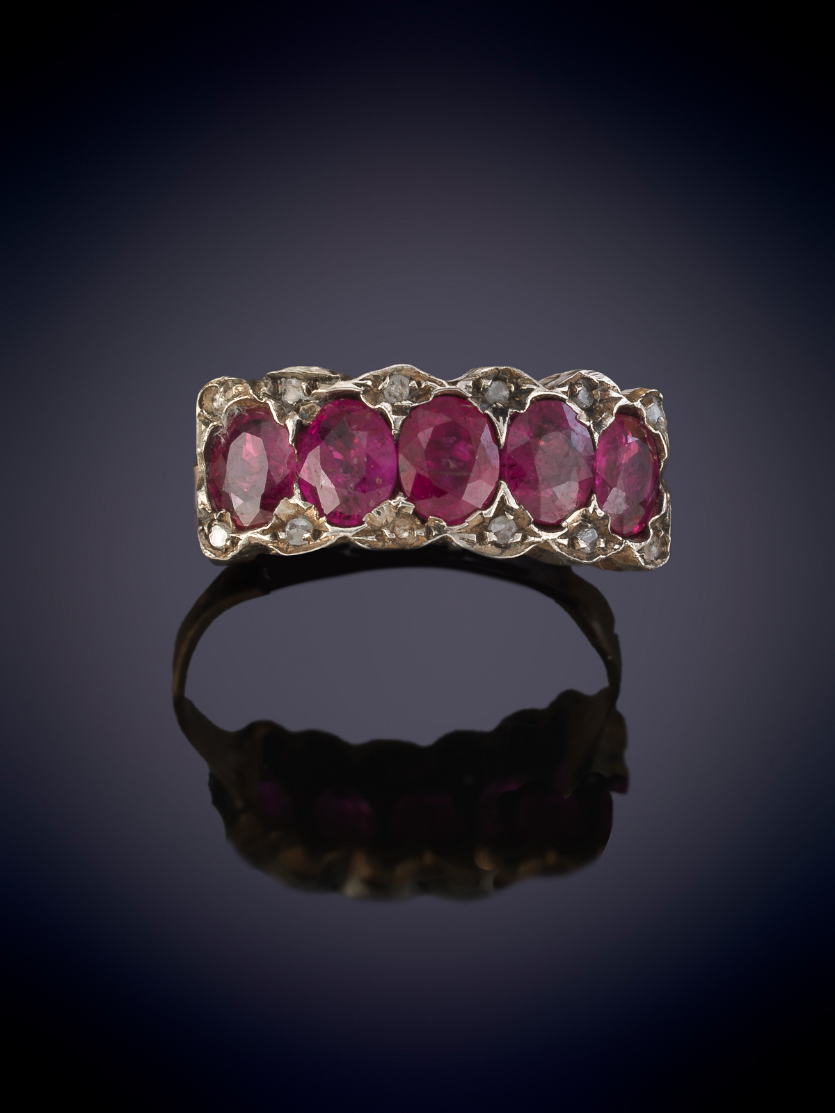 SORTIJA CINTILLO  CON CINCO RUBIES ORLADOS DE PEQUEÑOS BRILLANTES. Montura en oro rosa de 9k.