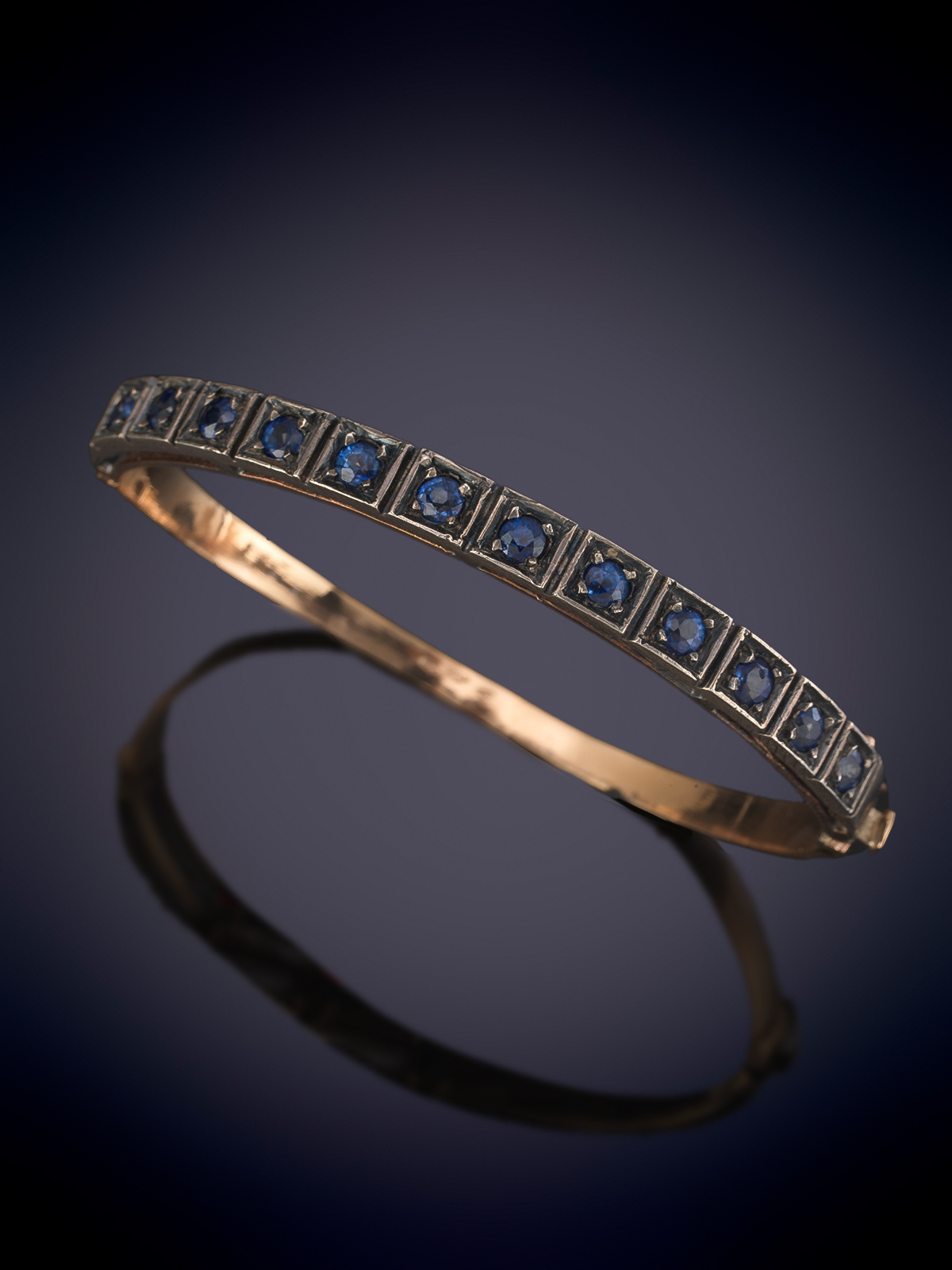 BRAZALETE RIGIDO DE ZAFIROS. Montura en oro amarillo y vistas de plata. Peso aprox. zafiros 9 cts.