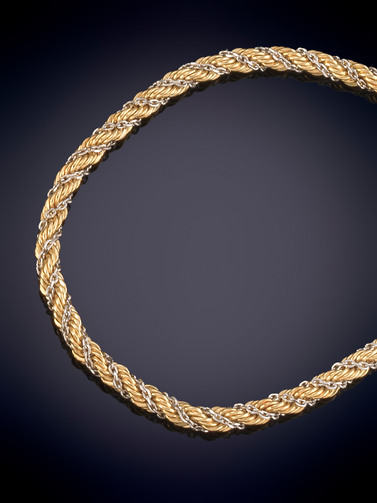PULSERA EN ORO AMARILLO TRENZADO CON FINA LINEA EN ORO BLANCO DE 18K. MODELO CORDÓN
