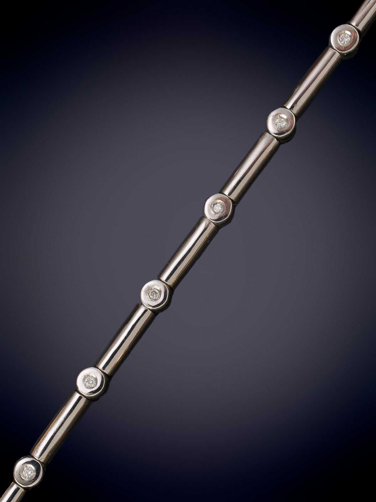 MODERNA PULSERA DE CHATONES DDE BRILLANTES UNIDOS POR BARRILETES EN ORO BLANCO DE 18K.