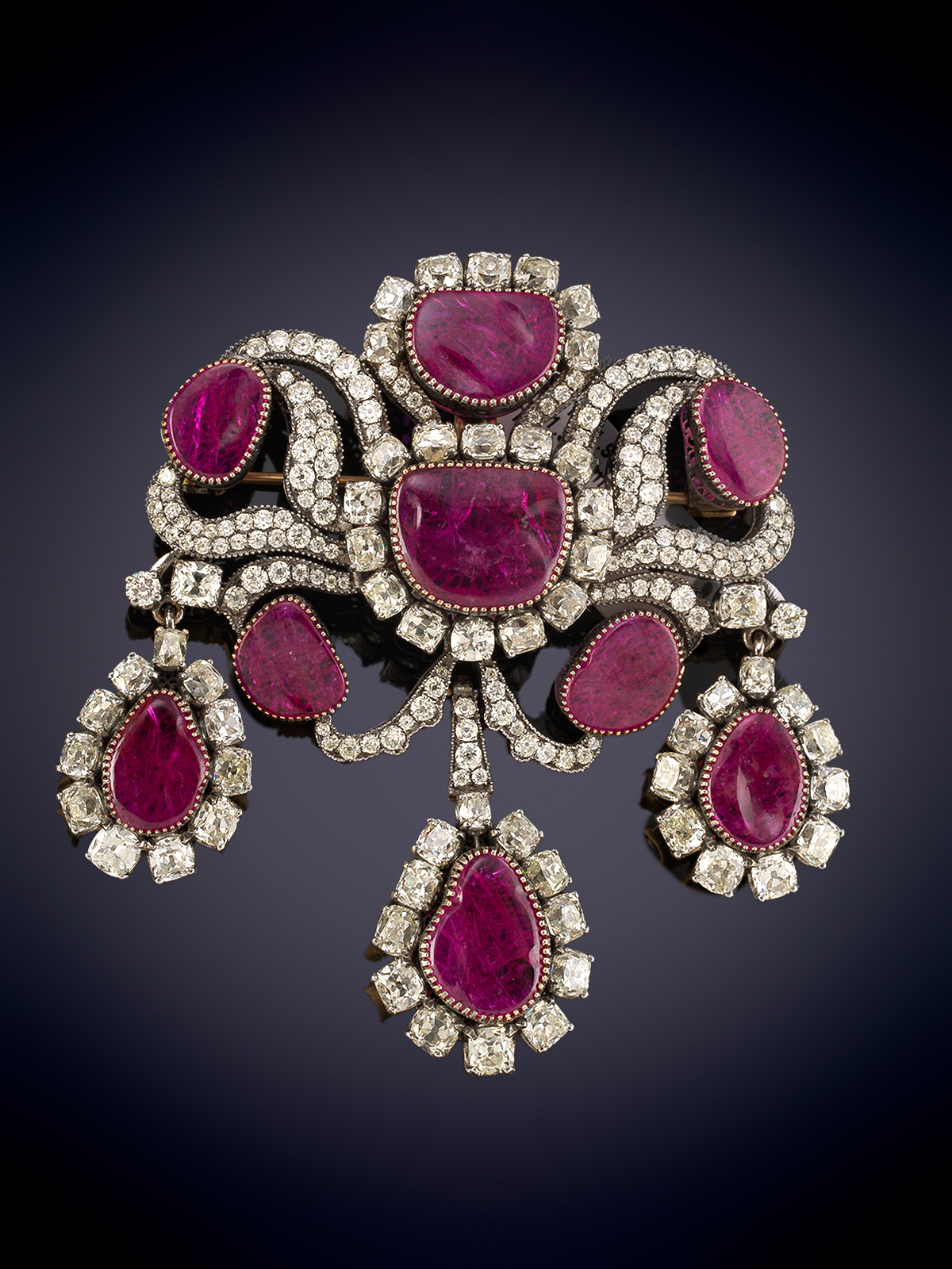 ELEGANTE BROCHE COLGANTE DE RUBÍES Y DIAMANTES. DISEÑO EN GIRANDOLE CON RUBÍES CON UN PESO APROX....