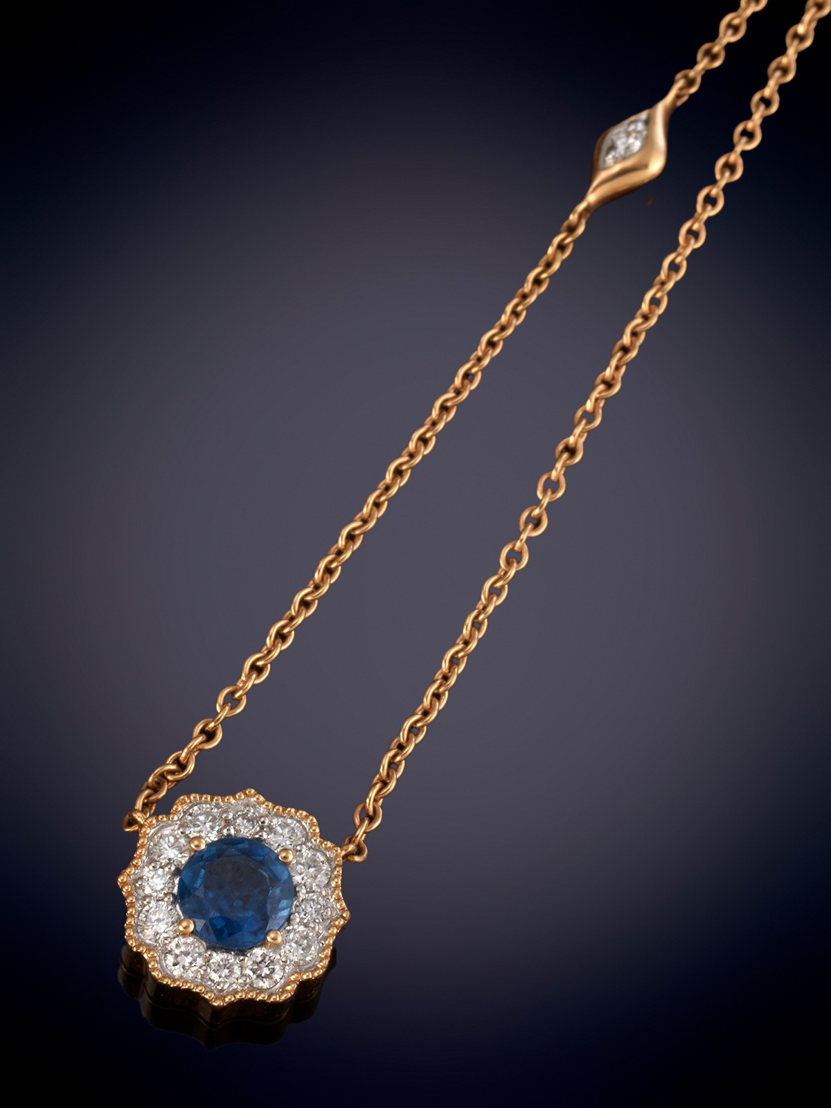 GARGANTILLA CON UN ZAFIRO TALLA CIRCULAR RODEADO DE BRILLANTES CALIDAD EXTRA. FINA CADENA EN ORO...