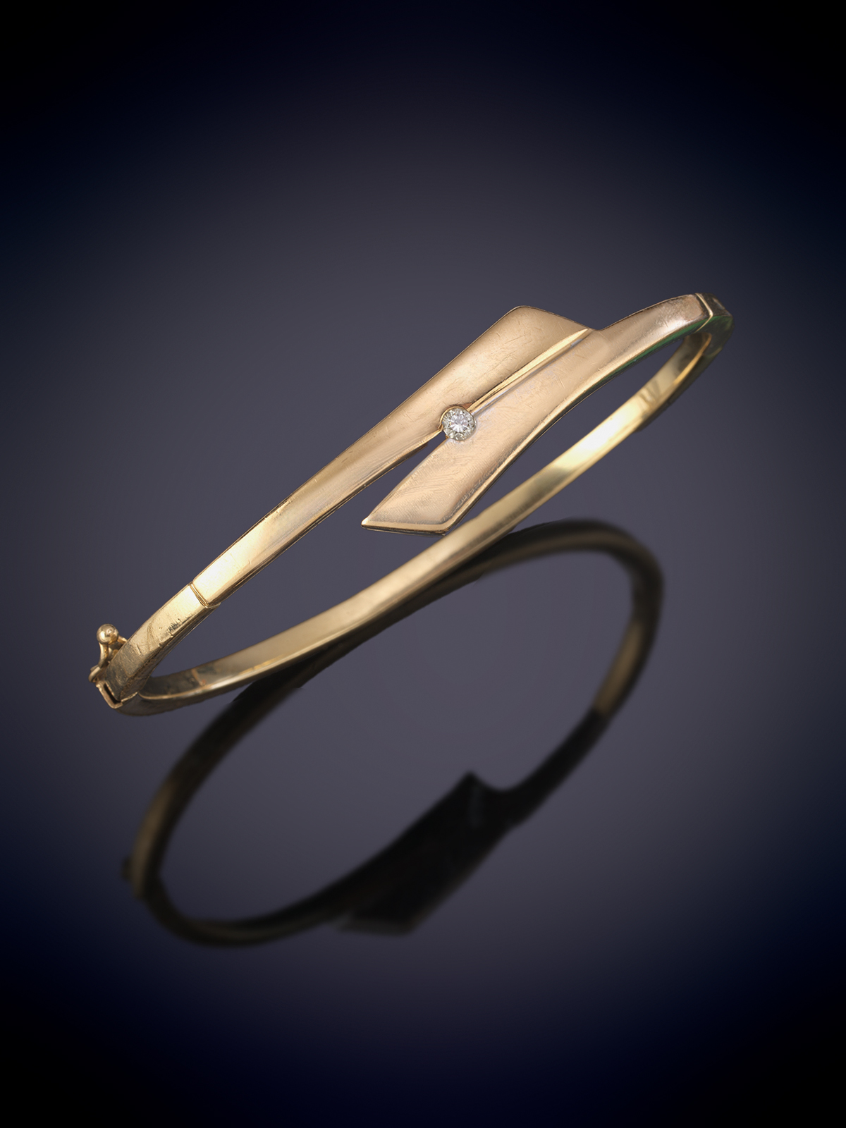 PULSERA DE MEDIA CAÑA EN ORO AMARILLO DE 18K. CON DETALLE DE BRILLANTE.