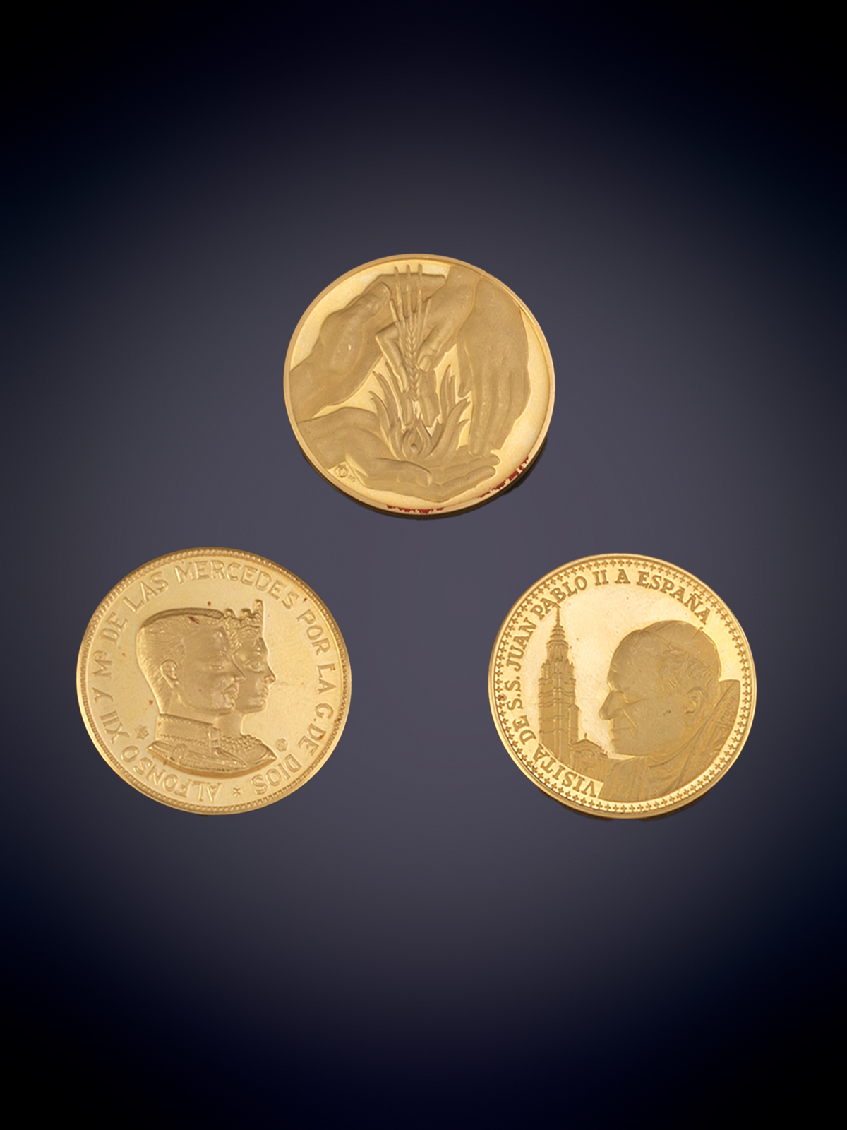 TRES MONEDAS CONMEMORATIVAS EN ORO AMARILLO DE 22K Y 18K. El papa Juan Pablo II, Alfonso XII y la reina María de las Mercedes y medalla conmemorativa de bodas de plata.