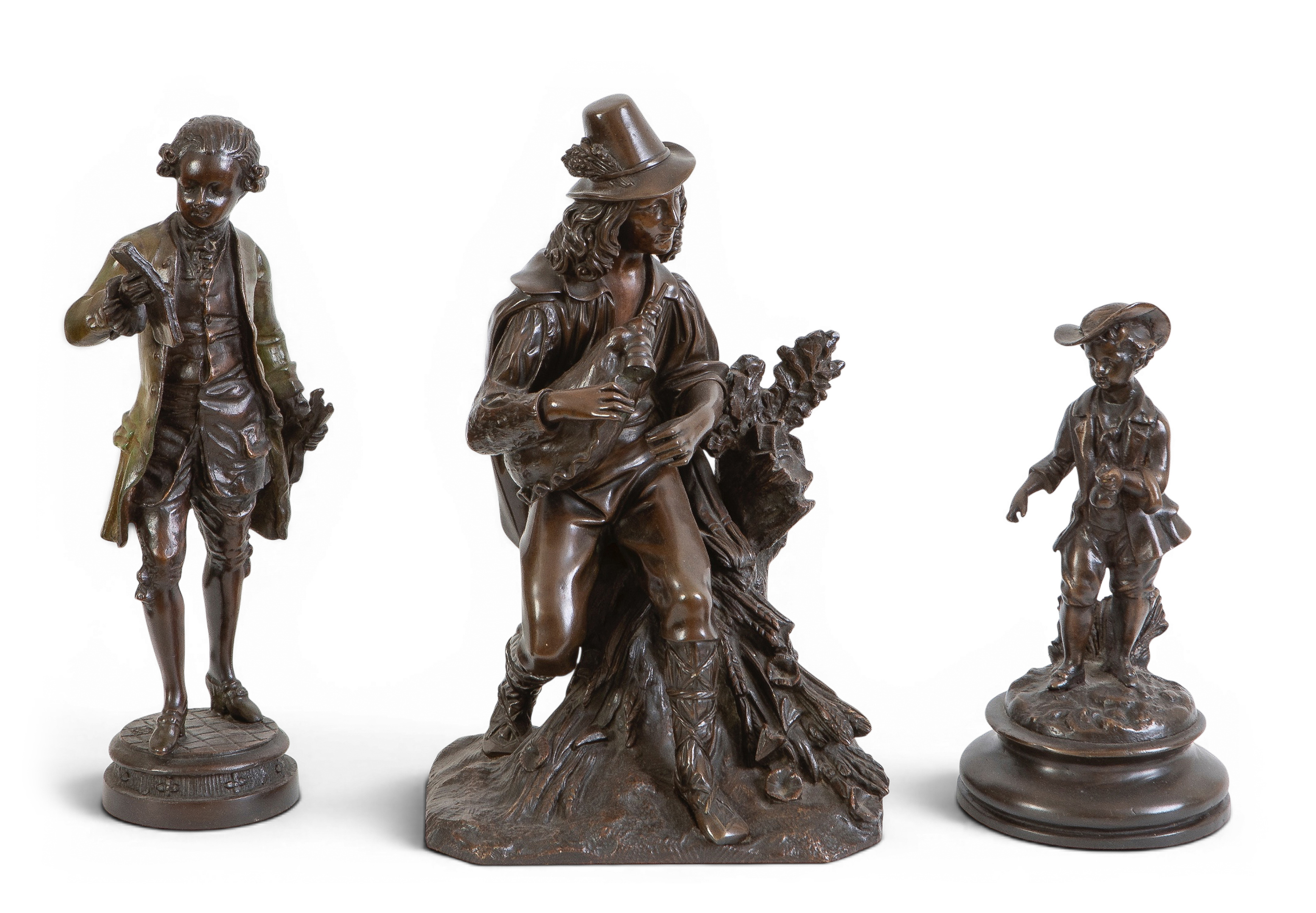 Lote de tres figuras en bronce pavonado; un gaitero, un zagalillo con sombrero y un...