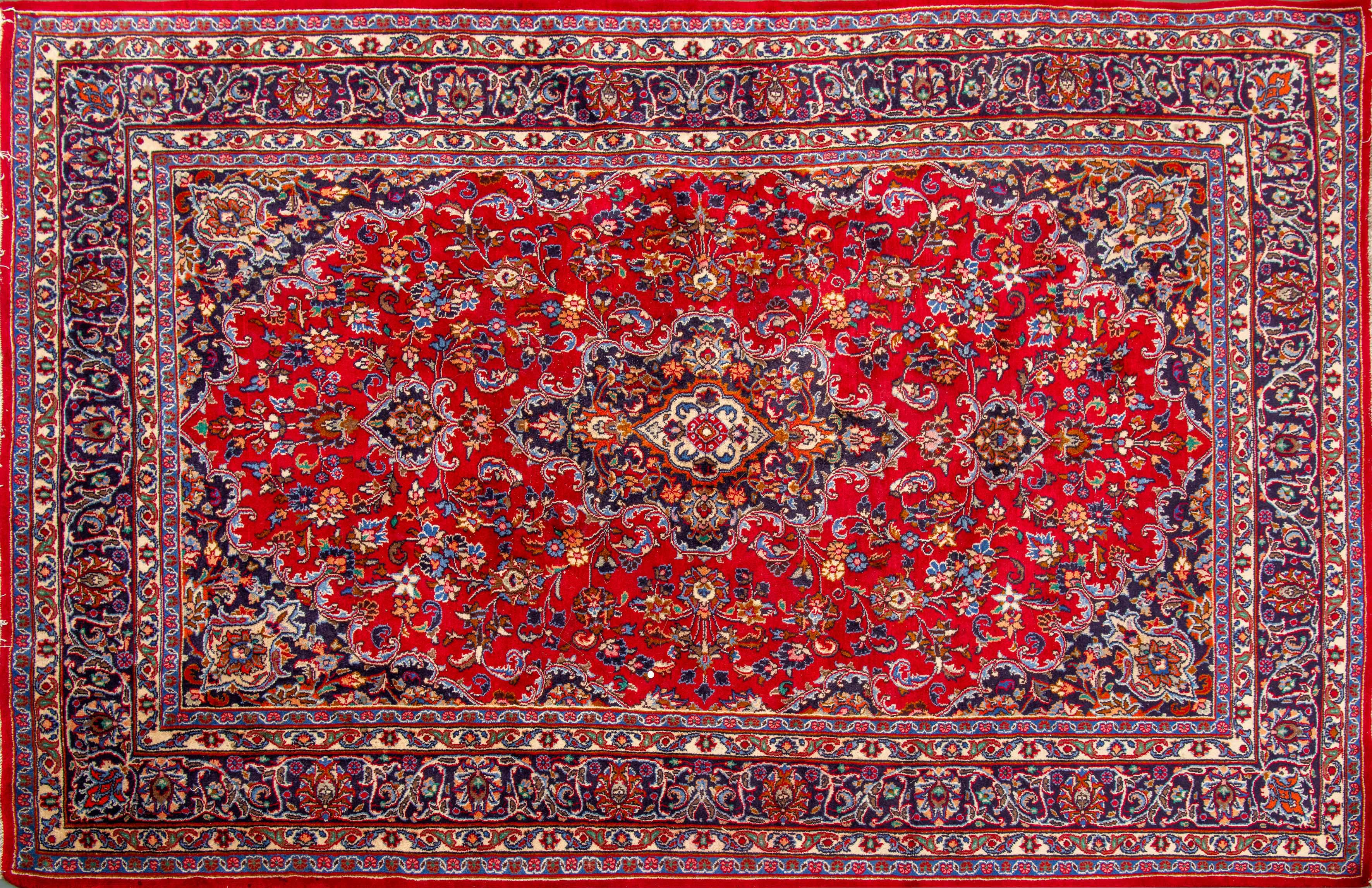 Alfombra de Isfashán, Irán S.XX. Campo de color carmesí con decoración de flores esquemáticas y...